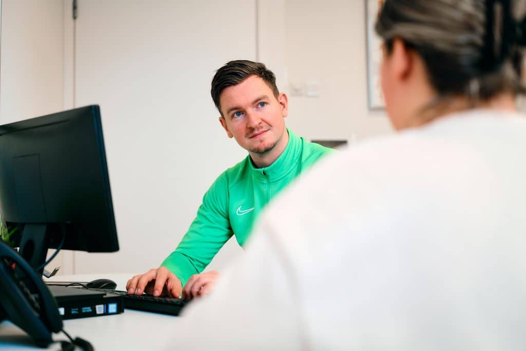 Fysiotherapeut interviewt patiënt